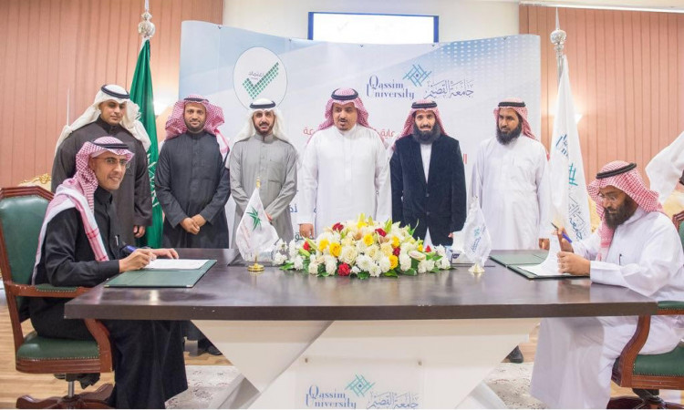 الاتصال ويجلس مجموعة من الرجال وهم وهم الغترة أو الشماغ السعودي مع العقال والبشت السعودي حول طاولة تواصل اجتماعيات وزهوراً، بالإضافة إلى شعارات جامعة القصيم، بينما يشرف معالي مدير الجامعة على مراسم توقيع الاشتراكات الرسمية مع هيئة التعليم الرسمي خلال الرعاية الرسمية.
