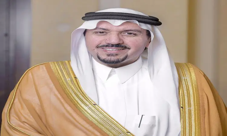 يرتدي الرجل ثوبًا تقليديًا، تعلوه غترة سعودية بيضاء مثبتة بعنق أسود، ويكستي بشتًا سعوديًا بني اللون مطرزًا بخيوط ذهبية، يبتسم باتزان أمام عدسة الكاميرا. تبدو الخلفية ضبابية بالنسبة لها الحيادية في المؤتمر الدولي لصيدلة المجتمع المنعقد في القصيم.