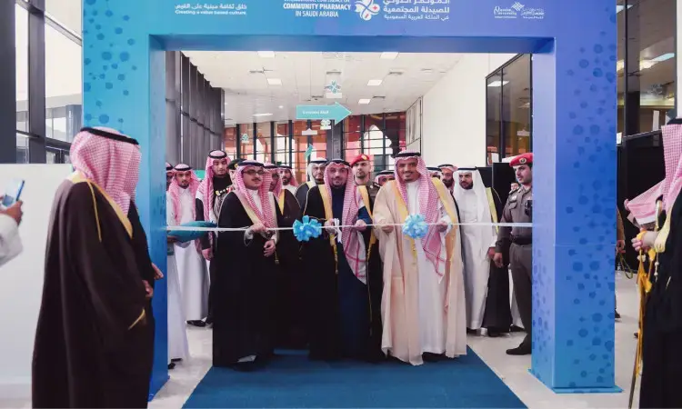 مجموعة من الحاضرين السعوديين الحاضرين الغترة أو الشماغ السعودي مع العقال، بالإضافة إلى البشت السعودي التقليدي، يتقدمهم سيد الأمير منطقة القصيم، ويتولى بقص الشريط الأزرق عند مدخل المبنى إيذانًا بافتتاح المؤتمر الدولي للصيدلة المجتمعية في المملكة العربية السعودية، وذلك ضمن فعاليات تأسيسها جامعة القصيم.