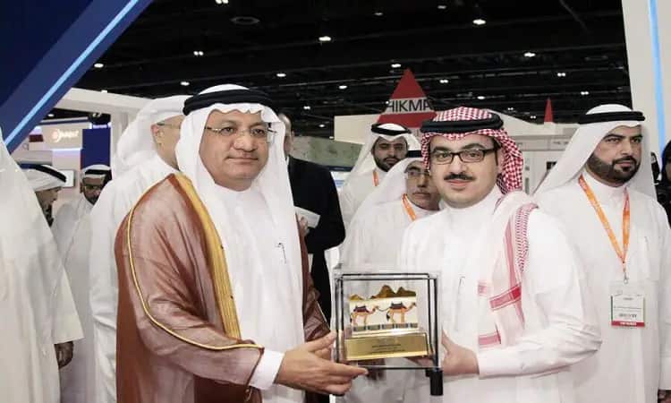 رجلان يرتديان الغترة والشماع والعقال، بالإضافة إلى البشت السعودي، عصران مجسماً لجائزة على هيئة جمل وذلك خلال خاطر يُحتمل ضمن فعاليات مؤتمر دبي للصيد. يشهد تاريخ مجموعة من الرجال بزي تكافؤ وأجنحة عرض متخصصة، مما يشير إلى اجتماع ذي طابع علمي علمي يركّز على الأبحاث المشتركة من جامعة القصيم.