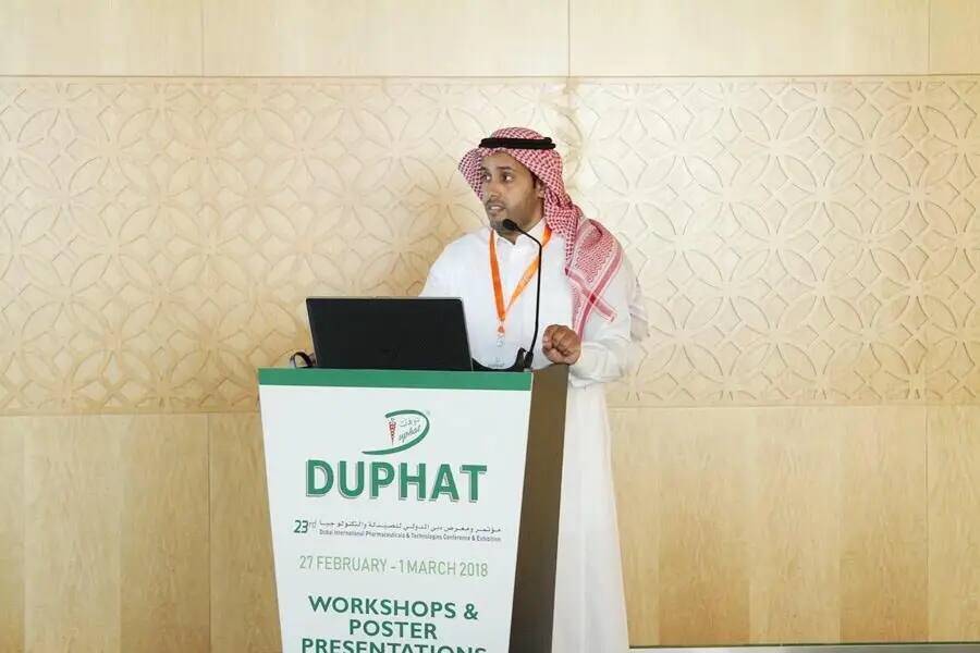 يُلقي أحد واضحين، مرتدياً الغترة السعودية والعقال والبشت السعودي الرسمي، كلمة في منصة DUPHAT خلال مؤتمر دبي للصيدلة. ويبرز على نطاق واسع تسليط الضوء على أعمال العمل والأبحاث العلمية، والتي تم تقييمها في الفترة من 27 فبراير حتى 1 مارس 2018.