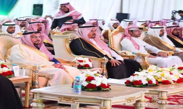 يجلس مجموعة فاخرة من الرجال مرتدين الشماغ السعودي والغترة السعودية مع العقال والبشت السعودي على كراسٍ داخلي ضمن بيئة مناسبة في منطقة القصيم، ويحتمل أن يكون ذلك في جامعة القصيم فرع عقلة الصقور، حيث يحيط بهم جميل من الورود، وتوسطهم طاولة مرصوفة بزجاجات المياه.
