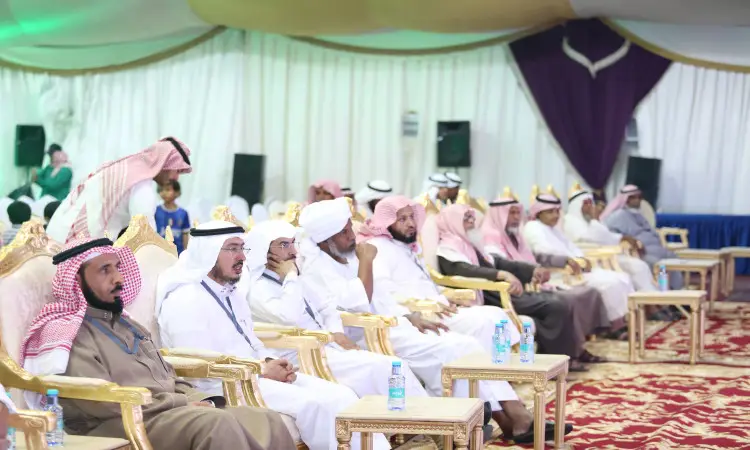 مجموعة من الرجال الفاخرين الغترة أو الشماغ السعودي والعقال والبشتاء السعودي يجلسون داخل كراس ذهبية خيمة زينة، وذلك أثناء حضورهم اجتماع الفعاليات التي تنظمها جامعة القصيم. لتناول الطعام أمامهم، كما يمكن رؤية بعض الحضور في الصفوف الخلفية.