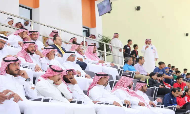 ترتدي مجموعة من الرجال، ترتدي العديد منهم مقاعد الغترة أو الشماغ السعودي مع العقال والبشت السعودي، في مدرجات داخل المسابقات الرياضية في القصيم، يتابعون إحدى الفعاليات. ويظهر في بعض الحضور بملابسهم الاعتيادية. ومن المحتمل أن تكون هذه الجامعة ضمن تصنيفات الجامعات السعودية أو منافسات كرة القدم للصالات.