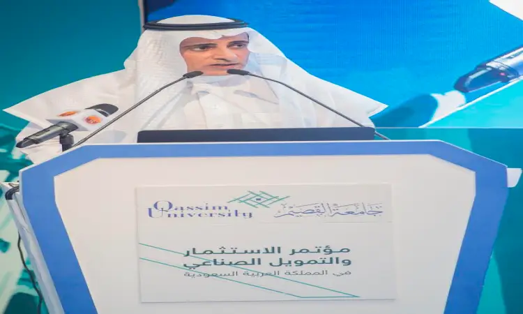 رجل مرتدياً البشت السعودي، وعلى الرغم من شماغ سعودي وعقال، يتكلماً من خلف منصة تحمل شعار جامعة القصيم من خلال مؤتمر حول الاستثمار والتمويل المملكة الصناعية. ويحيط بالمنصة عدد من الميكروفونات الخاصة بنقل كلماته للجمهور.