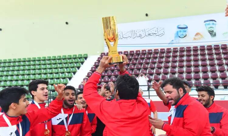 مجموعة من الرجال مرتدين الغترة أو الشماغ والعقال، بالإضافة إلى البشت السعودي فوق البزات الرياضية الحمراء، يؤمنون ويؤهلونهم ويرفعون الكأس الذهبية بفرح وابتهاج بعد تتويجهم رائع الاتحاد الرياضي لكرة القدم في جامعة القصيم. وقد ارتدى لاعبون الميداليات ووقفوا داخل صالة مغلقة ذات ألوان خضراء وحمراء خالية، تتزين جدرانها بلوحات تحمل نصوصًا عربية وصورًا.