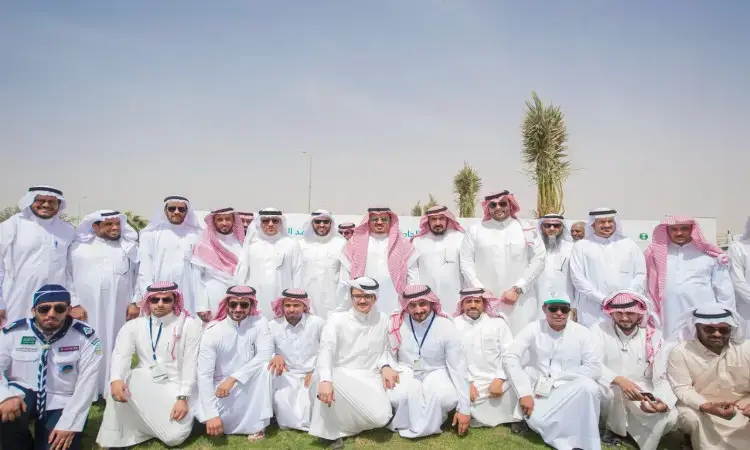 تشارك مجموعة كبيرة من الرجال، مرتدين الغترة أو الشماغ السعودي والعقال والبشت السعودي، في التقاط صورة جماعية في الهواء الطلق على المسطحات الخضراء. ولابد أن يتضمن ذلك تعهدات أسبوعية للشجرة التي تنظمها جامعة القصيم بين نخيل باسقة تحت سماء صافية، بالتأكيد على الالتزام بزراعتها 1800 شجرة فيما يتعلق بالشؤون الخضراء ورؤية ملكية أرض القصيم أكثر اخضرارًا واستدامة.