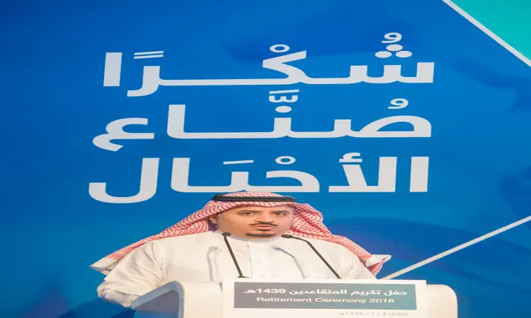 رجل يرتدي غترة بيضاء، عقالاً وشماغاً سعودياً، بالإضافة إلى بشت سعودي تقليدي، فجأةً من خلف المنصة أمام فرنزر يتوسطها نص باللغة العربية وبارة "حفل التقاعد 2018" باللغة الإنجليزية، وذلك خلال المتقاعدين الذي نظمته جامعة القصيم.