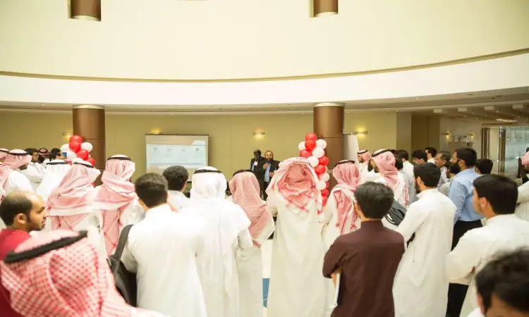 اجتمع عدد كبير من رجال مرتدين الشماغ أو الغترة السعودية مع العقال والبشت السعودي داخل أحد القاعات، حيث كانوا يجهلون المتكلمين عن زينة بالونات بالأحمر والأبيض وشاشة عرض تقديمي. جاء هذا التجمع احتفاءً بتدشين قطاع بين أكاديمية أوراكل وكلية الحاسب في القصيم.