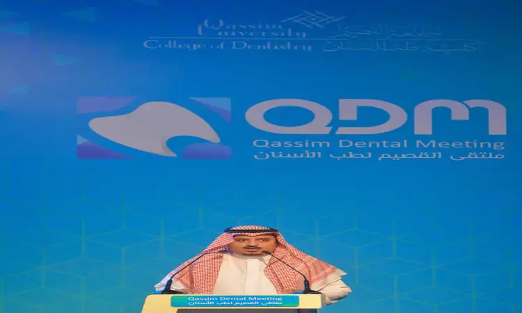 رجل يرتدي غترة سعودية وعقالاً وبشتاً رسمياً خلف منصة الخطابة العامة خلال ملتقى القصيم لطب الأسنان، لتناول الخلفية في شعارات كلية طب الأسنان في القسيم والفعالية على خلفية زرقاء.