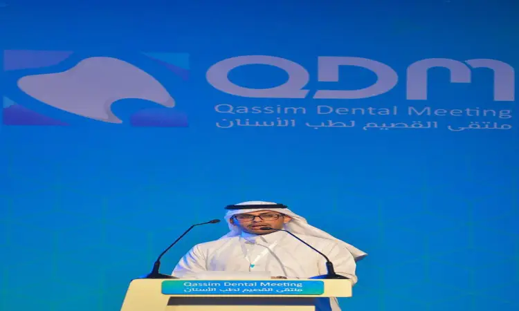 رجل القط مرتداً الغترة أو الشماغ والعقال، وقد تدثر بالشت السعودي، مشهوراً من على منصة الخطابة خلال فعاليات ملتقى القصيم لطب الأسنان في القصيم. وخلفه شعار الملتقى واسمه باللغتين العربية والإنجليزية على خلفية زرقاء.