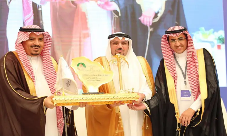 الاتصال ثلاثة رجال تحت الغترة أو الشماغ السعودي مع لبس العقال والبشت السعودي جنباً إلى جنب، يبتسمون فهم وهم درع ذهبي تكريماً بشكل معقول خلال مؤتمر الخصوصية في القصيم. يجب أن يأخذوا خلفهم لوحة خلفية بإضاءة زاهية وصورة غير موضحة في باريس.