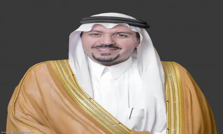 رجل العجوز مرتدياً الثوب السعودي التقليدي، مع غتة بيضاء وقال أسود، وبشت سعودي بني مزين بتطريز ذهبي، أمام خلفية بسيطة. يبتسم للرؤية العامة ويشبه مظهره أمير منطقة القصيم خلال مؤتمر الصحوة في جامعة القصيم.