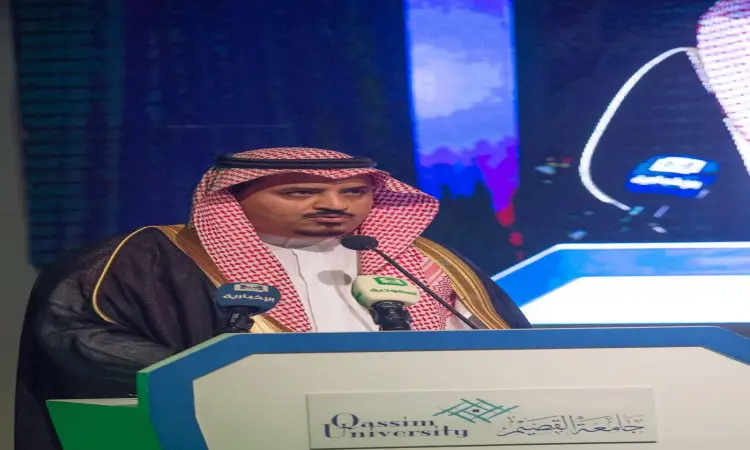 رجل يرتدي الزي السعودي التقليدي، يشمل غتة بيضاء، عقالاً، وبشتاً سعودياً أنيقاً، وقد تم التعريف به باسم أمير القصيم، أثناء إلقائه كلمة من على منصة تحمل شعار جامعة القصيم خلال مؤتمر المجتمعوة. وتواجد أمامه ميكان، بينما تظهر شاشة كبيرة خلفه صورته وهو يلقي كلمته في هذا الحدث الرسمي.
