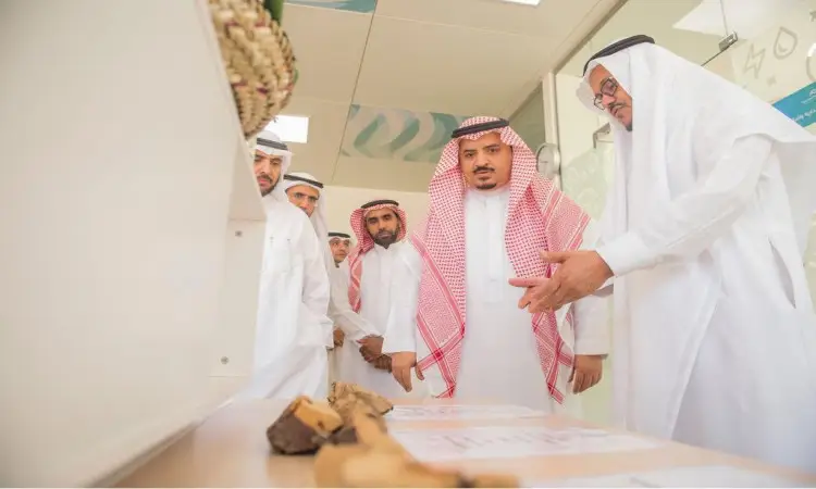 الاتصال مجموعة من الرجال مرتدين الغترة أو الشماغ السعودي مع العقال والبشت السعودي، يتقدمهم مدير الجامعة، حول طاولة في قاعة حديثة. ويناقش الجميع مواضيع الاهتمام المتعلقة بمركز التنمية الاجتماعية وجائزة التميز والتميز البيئي، وذلك في إطار رسمي يعكس مكانة جامعة القصيم والتزامها بالتميز الوطني.