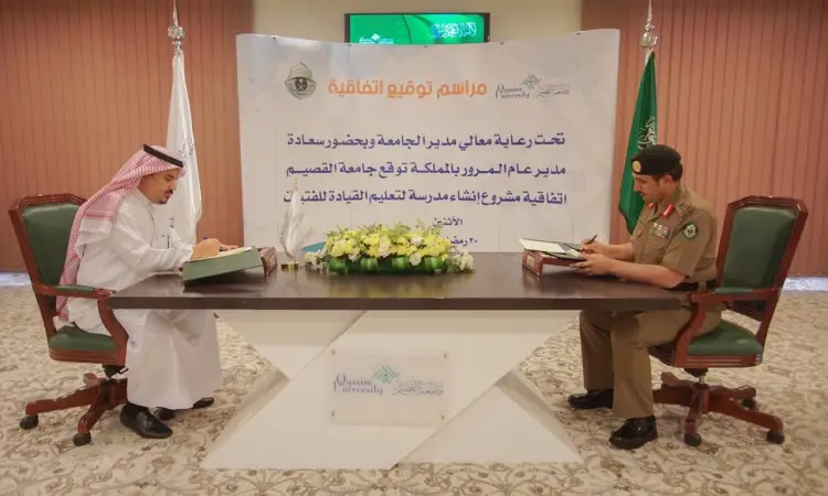 Place two men on a documentary signing table; one wears the traditional Saudi Ghutrah, Eqal and Bisht, while the other wears a formal military uniform. "Qassim University" and "Driving School" are inscribed in Arabic text in the background, and the Saudi flag is clearly visible in detail, adding an official precision to emphasize the cooperation between the groups.