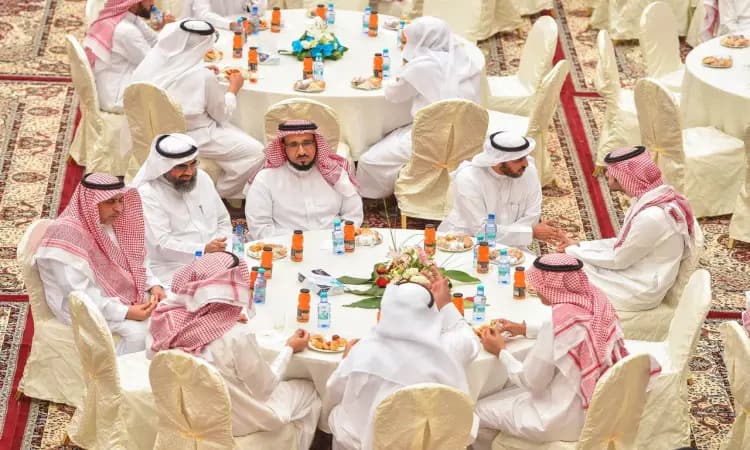 يجتمع جمع من الرجال مرتدين الغترة أو الشماغ السعودي مع العقال، وقد ارتدى المشترك البشت السعودي اختار، حول موائد مستديرة في قاعة مخصصة للحفلات الرسمية بمناسبة عيد الفطر المبارك في جامعة القصيم، حيث يتبادلون التهاني ويتناولون أصناف المعبأة والحلويات ضمن شاملة تليق بالمقام الجامعي.