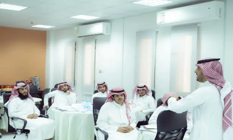 يجتمع مجموعة من الرجال مرتدين الغترة أو الشماغ السعودي والعقال، ويضع الشركاء البشت السعودي، في قاعة ذات جدران بيضاء وإضاءة فلورية ضمن بيئة تعليمية في جامعة القصيم. ويحضرون وهم يجلسون حول الجداول التي تهتم بالأب يصغون إلى مقدم البرنامج، وذلك ضمن إطار برنامج تطوير لتعزيز وتعزيز المهارات القوية.