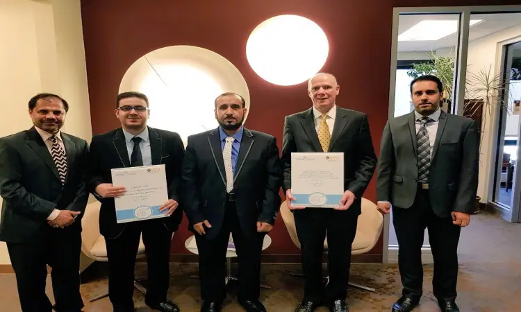 خمسة رجال تولى الزي الرسمي، يشمل الغترة أو الشماغ والعقال والبشت السعودي، الاتصالون في مكان مغلق. اثنان منهم، يمثلان كلية الصيدلة في فيرجينيا كومنولث، عصران شهادتان للطلاب بابتسامة، في ما يبدو أنها تدشين لاستخدامات جديدة مع جامعة القصيم. يظهر رأسها خمسة ديكورات ونافذة يتخللها ضوء طبيعي وتزينها بغطاء خارجي.