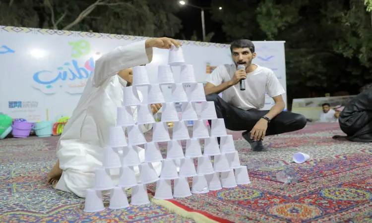 خلال فعاليات مهرجان عطلة المذنب، شوهد طفل يرتدي زيًا جديدًا في الهواء الطلق مع غترة سعودية وقال وهو يقوم بترتيب أكواب بلاستيكية على شكل هرم، وذلك بفضل سجادة مزخرفة للغاية في الهواء الطلق. وفي الجوار، كان أحدين مرتدياً البشت السعودي ويجلس بالقرب من الطفل ممسكاً بهيئة تنظيمية. وقد أُقيمت هذه الفعالية بحضور لافت أمام شعار جامعة القصيم تحت تحت ظلال الظلال بالمكان.