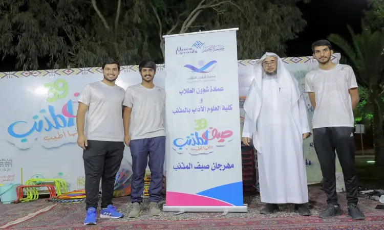 اتصل بأربعة رجال في الهواء الطلق في الهواء الطلق ومجسم ملون لمهرجان "صيف المذنب". يرتدي ثلاثة منهم ملابس أو شبه، بينما يظهر الرابع وهو يرتدي الغترة السعودية والعقال والبشت السعودي. وتضفي شجرة النخيل وأضواء الليل كثيفة بالمكان، رسمياً تعبّر عن برامج صحية تقيمها جامعة القصيم ضمن فعاليات موسم الصيف.