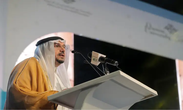 رجل يرتدي عادة غترة سعودية، شماغ، عقال، وبشت سعودي من خلف منصة تعلم بميكروفونات وذلك خلال نهائي جائزة جود الدولية. وفكر على أميراً هوية الجائزة الرسمية، بما في ذلك يبرز شريف صاحب السمو صاحب السمو منطقة القصيم لهذا السبب الذي ساعده جامعة القصيم.