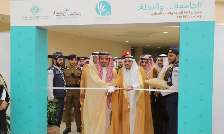 سمو أمير منطقة القصيم ومسؤولو جامعة القصيم يقظة الغترة أو الشماغ السعودي مع العقال والبشت السعودي أثناء حضورهم في الفعالية الرسمية لافتتاح الفعالية وكريم الفائزين وجود جود الدولية، وذلك بحضور فرق الأمن والمصورين في الخلفية.