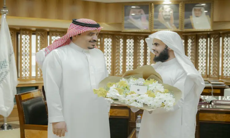 رجلان يرتديان الزي السعودي الرسمي المكون من الشماغ والعقال والبشت داخل مبنى الجامعة. نعمل على التركيز على البيضاء والصفراء ونبتسم لسعادة مدير الجامعة في مكتب تتزين جدرانه بصوره خلفية فقط حيث علم المملكة في.