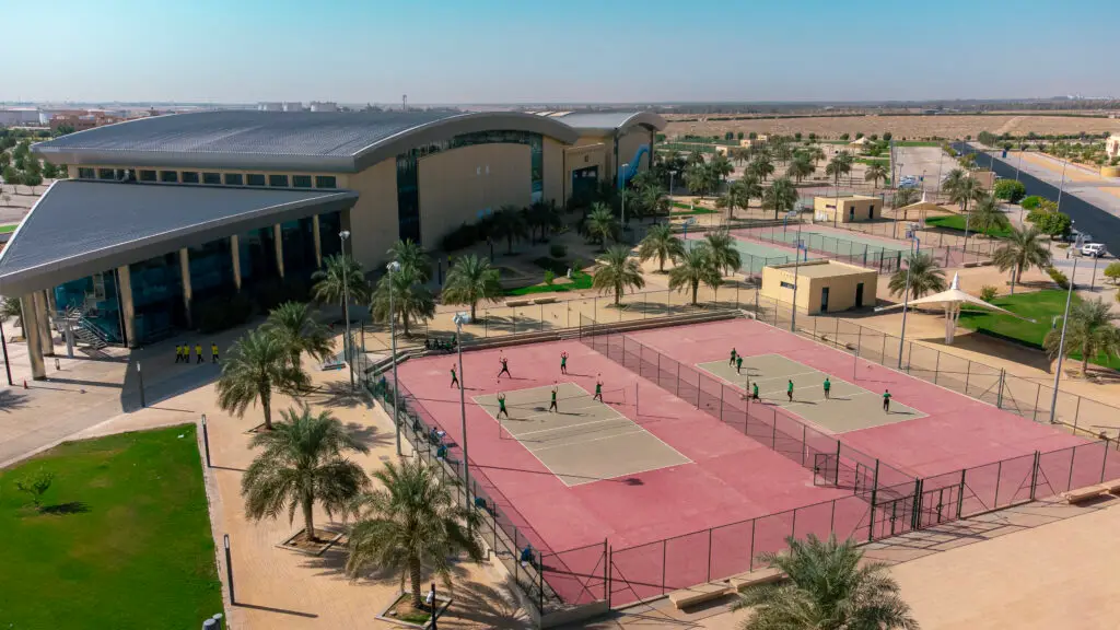 منظر جوي لحرم جامعة حديثي الولادة، حيث يوجد مبلغ صغير من الشركات الناشئة، بالإضافة إلى ملعب رياضي خارجي ذي الأرض الحمراء يُمارس في أنشطة تهدف إلى تطوير الأنشطة الترفيهية. قطع المنطقة المجاورة للمناطق السكنية المتضررة بالطرق والمساحات الواسعة، مع الالتزام بالمظهر الرسمي المناسب لجامعة القصيم؛ حيث مطلوب الشماغ السعودي أو الغترة السعودية حسب الأعراف المحلية.