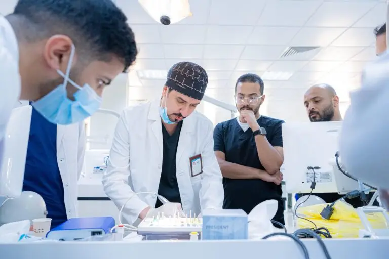 يتجمّع عدد من الرجال، تنشأ المنظمات المتعاطفة والخبرية والكمامات، حول طاولة مختبر في طب الأسنان بكلية طب الأسنان. ويركزون عليهم على عرض ما يقدمه أحد الحضور مرتدياً معطفاً أبيض وغترة سعودية ذات نضوج، وذلك ضمن تعليم الأطفال في القصيم.