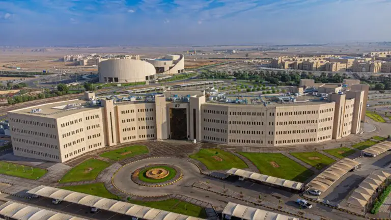 مبنى جامعي حديث العهد وشامل لواجهة موسيقيّة، مخصص لقطاع الدراسات العليا والعلمية في جامعة القصيم، ويحيط به رياضات رياضية خضراء، ومواقف السيارات، وشبكة من الطرق. يظهر المبنى في هيكل الحرم الجامعي مع وجود منشآت أكاديمية إضافية ضمن بيئة طبيعية ذات طابع صحي تحت سماء زرقاء صافية.