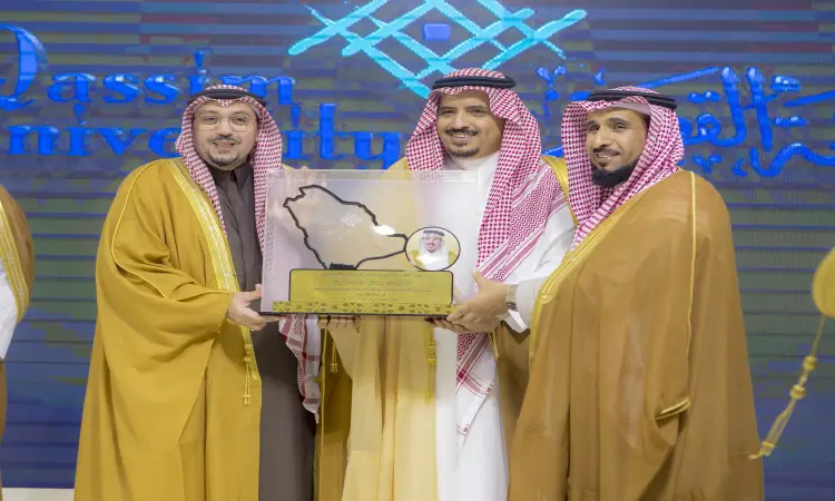 ثلاثة رجال تولى الزي السعودي الاربعة الرسمي في الغترة أو الشماغ مع العقال والبشت السعودي، الاتصال مع مبتسمين ويحملون كأسًا خفيفًا يعلوه مجسم لخريطة المملكة العربية السعودية وصورة بارزة، وذلك أمام خلفية تحمل نصوصًا باللغتين العربية والإنجليزية احتفاءً بحملة الجامعة التي نظمتها جامعة القصيم في مقاطعة ضرية القصيم.