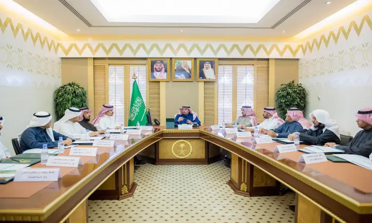 يجتمع عدد من الرجال مرتدين الغترة أو الشماغ السعودي مع العقال والبشت السعودي حيث طاولة مخصصة للمناسبات في جامعة القصيم، حيث يناقشون شؤون التعليم العالي السعودي. وتزين القاعة أعلام المملكة العربية السعودية وغير ذلك من المنازل، مما يضفي على الاجتماع مسئولياً دلالة الهوية الوطنية.