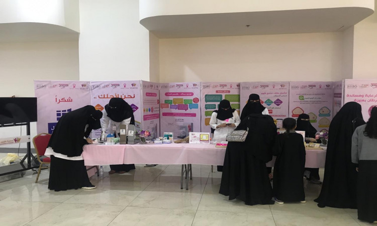 اتصل بعدد من مرتديات العبدة والنقاب في جناح كلية الطب بزة عني، حيث يشاركون في عرض مواد توعوية ومنشورات تعريفية عن سرطان الثدي والتفاعل مع الزوار داخل القاعة العامة. ويبرز حضور الرجال بارتداء الشماغ أو الغترة والعقال والبشت السعودي، بما في ذلك يُضفي على مسئولية رسمية ويتابع بمكانة جامعة القصيم ودورها الريادي في خدمة المجتمع للتوعية الصحية.
