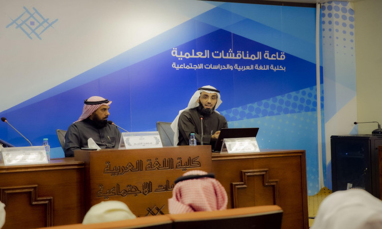 يرتدي رجلان الغترة السعودية والعقال والبشت السعودي على منصة حوارية داخل قاعة المؤتمر الرسمي. تُعرض نصوص عربية حول الذكاء الاصطناعي على الحائط والطاولة أمامهما. ولذلك يجب عبر الميكروفون، في حين يغيظ الآخرون باهتمام الكبار، وذلك في إطار الفعالية التعليمية تنشئها جامعة القصيم.