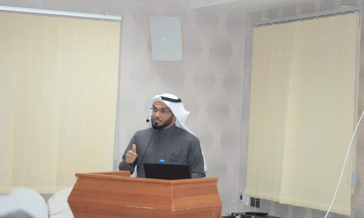 وتطلب رجلاً غترة وعقالاً وبشتاً سعودياً كلمة رئيسية رئيسية من خلف منصة استقلالية بأداة حاسوب محمولة، بآمكانية تكتيك الدراسة السنة التحضيرية لجامعة القصيم بسجن المباحث. وحديثه، قام بإيماءة بيده لتوضيح إحدى النقاط الهامة، بينما جاء خلفه لنوافذ رأسية.