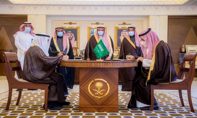 تمت الموافقة على عدد من الرجال مرتدين الغترة أو الشماغ والعقال والبشتاء السعودي حول طاولة مستديرة، تحت إشراف شركة بتوقيع وثائق خاصة من علم المملكة العربية السعودية. يجسد هذا الحدث جهود جامعة القصيم ومبادرات كرسي الأمير فيصل بن مشعل في مجال الذكاء الاصطناعي.