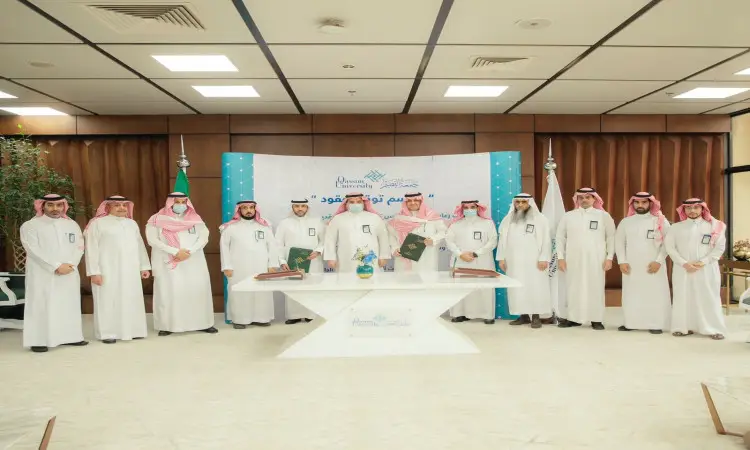 الاتصال مجموعة من الرجال بزي سعودي تقليدي، الشماغ السعودي أو الغترة والعقال والبشت، في قاعة الاجتماعات خلف تحتوي على طاولة على وثائق، وذلك من خلال التقاط صورة تذكارية أثناء مراسيم توقيع عقد النظافة والتشغيل والصيانة في المدينة الجامعية في القصيم. وتُعرض في الخلفية لافتات وعلامات تضفي على مبدأ أساسي بشكل رسمي ورسمي.