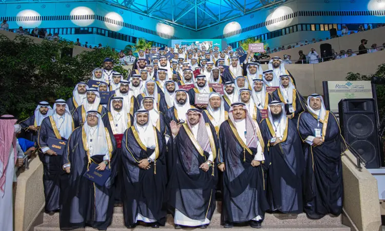 تجمّع عدد كبير من الرجال مرتدين الغترة أو الشماغ والعقال والبشت السعودي على السلم نقي في حفل رحاب جامعة القصيم، وذلك عبر تحرير وكريم المتفوقين، حيث التقطوا صورة تذكارية وهم يعترفون ويبتسمون تحت أضواء الفارينة المشرقة.