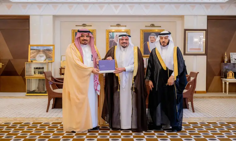 لستة ثلاثة رجال تولي الزي السعودي التقليدي، متمثلًا في الغترة أو الشماغ مع العقال والبشت السعودي، داخل الجامعة. ويظهر على وجوههم الابتسامة بشكل جزئي، كما أنها مشتركة. فكر في خلفية الصورة المبتكرة والموضوعية، مما يضفي طابعًا جذابًا على ما يلي في القصيم.