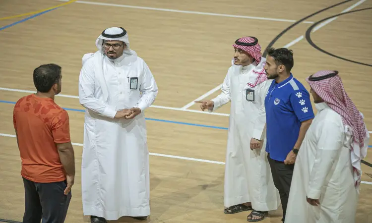 اتصل بخمسة رجال يتبادلون الحديث داخل الملعب مغلق؛ حصل ثلاثة منهم الثوب السعودي التقليدي مع الشماغ أو الغترة والعقال، كما أنه أحد البشتات السعودي، إذ ارتدى قمصان رياضية. يوحي هذا المشهد المضحك بمناقشة بين فعاليات النادي الصيفي أو التابعة لجامعة القصيم ومدرب الفريق.