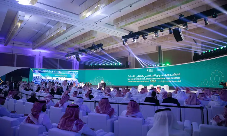 قاعة مؤتمرات واسعة في الرياض تكتظ بالحضور، وقد ارتدى المشاركون الغترة أو الشماغ والعقال مع البشت الرسمي السعودي، يجلسون في قاعة المشاهير حيث يستمعون إلى نصوص عرضت حول المؤتمر والمعرض الدولي للمهندسين. تضيء أنوار ساطعة بجانب القاعة، ويعم المكان للجميع احترام مكانة الحدث وأهميته الأكاديمية تحت ضوء جامعة القصيم.