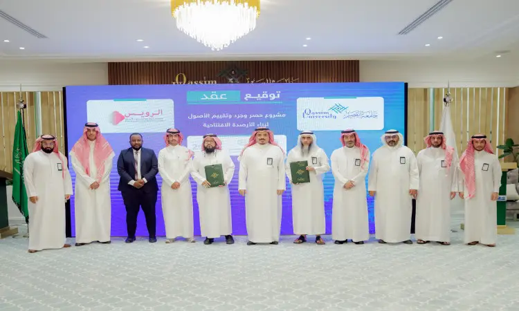 A mix of green men from the Saudi Ghutrah, Aqal and Bisht to a portion of children's suits and finally a photo during a contract signing ceremony for an asset inventory in Qassim, pictured are two temporary men, behind them is a large digital screen displaying text in Arabic.