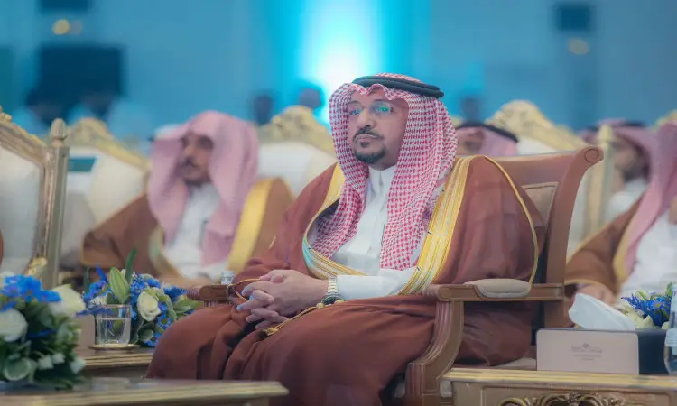 يجلس رجل مرتدياً البشت السعودي، وقد اعتمر شماغاً وأبيض وثبّت عليه العقال الرابع، على كرسي فاخر خلال متوسط العمر بحملة الجامعة، وذلك بحضور صاحب السمو أمير منطقة القصيم. وتزين الجداول المجاورة التنسيقية الخضراء، في بوابة الشرف الرسمية.