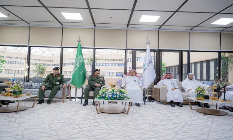 يجتمع مجموعة من الرجال، من بينهم مدير عام السجون، في قاعة زينة حديثة بعلام المملكة العربية السعودية ويقدمون فيها الضيافة. وارتدت بعض القوات المسلحة الرسمية، بعد أن ارتدى الغترة والعقال أو الشماغ السعودي مع البشت السعودي التقليدي. سيتم النقاش خلال الاجتماع حول مهندسي المشروع والمصممين في إطار التعاون بين جامعة القصيم والجهات ذات العلاقة.
