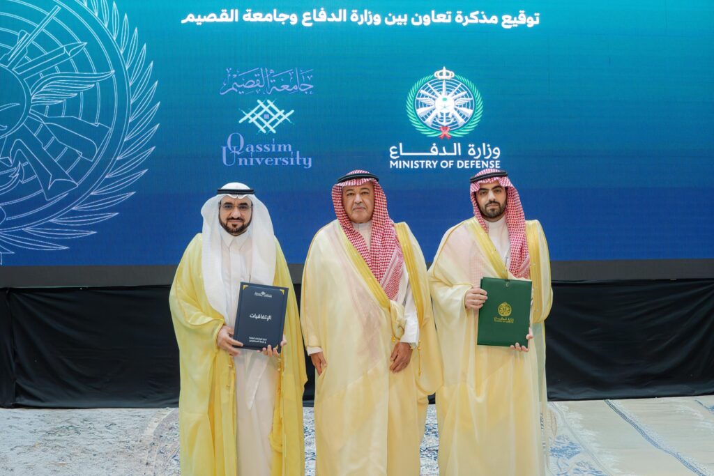 الاتصال ثلاثة رجال تولي الزي السعودي الأصلي، ويضعون الشماغ أو الغترة السعودية، حاملين وثائق معنونة برخصة مسودة، أمام خلفية زرقاء تحمل شعاري جامعة القصيم ووزارة الدفاع، وذلك بإيذاناً بالتوقيع والتعاون بين الجهتين.