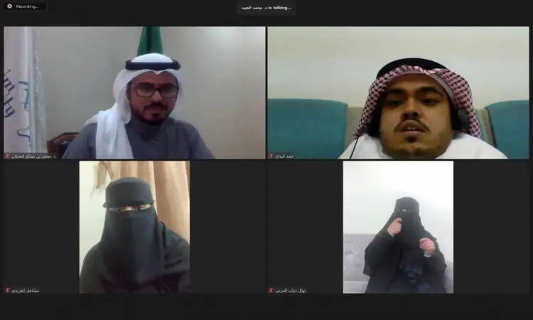 لقطة شاشة للاجتماع الافتراضي تضم أربعة مشاركين، وثلاثة رجال وامرأة واحدة. ارتدت الرجال الشماغ السعودي أو الغترة السعودية، بينما كانت السيدة نقاباً أسود. يدور النقاش حول الهدف العاشر من أهداف التنمية، وذلك في إطار اللعبة الرسمي في القصيم.