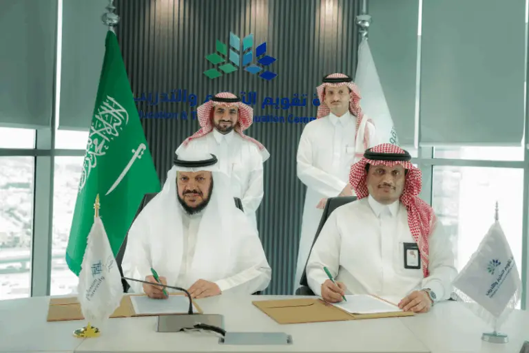 الرجال تواجدوا شماغاً أو غترة سعودية يتواجدون أمام طاولة مراسم أربعة توقيع، حيث يقوموا بقص وثائق أقلام على الجدول، في مشهد يعبّر عن الالتزام بالهدف الرابع. أبرز خلفهم أعلام المملكة العربية السعودية والمؤسسة الاجتماعية وشعار الجامعة، بالإضافة إلى تقرير الظاهرة في الخلفية.