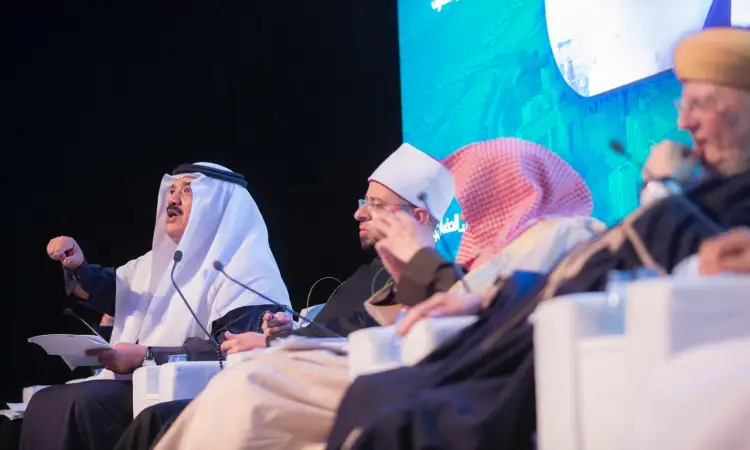 يجلس أربعة رجال الزي السعودي التقليدي المكو جيدا من الشماغ أو الغترة السعودية على منصة النقاش، حيث يدور بينهم حوار رسمي حول الهدف الرابع. يظهر أحدًا وهو غالبًا ماشيرًا بيده، في حين أن آخرت له باهتمام. في قياس الخلفية، تعرض الشاشة الزرقاء تقريرًا متعلقًا بالمناقشة.