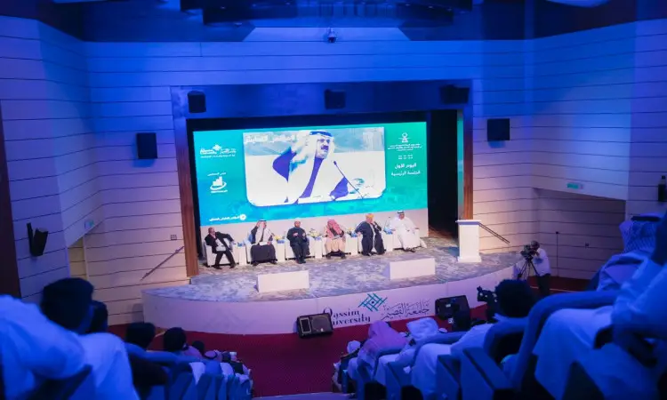 يجلس الفريق من المقررين على منصة القاعة في قاعة الانتظار في القصيم، بينما تعرض على الشاشة الكبيرة صورة لرجل يرتدي الشماغ السعودي أو الغترة السعودية. ويتابع تقدمون مجريات النقاش الذي يتمحور حول تقرير تناول الهدف الرابع.